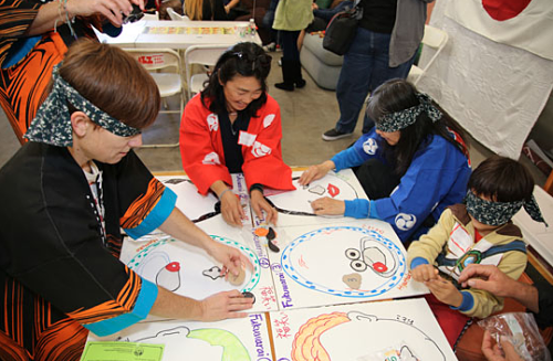 Một nhóm người chơi đang trải nghiệm Fukuwarai trong một sự kiện văn hoá.